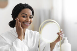 A woman examines her face after Laser Hair Removal in Lakewood, CO